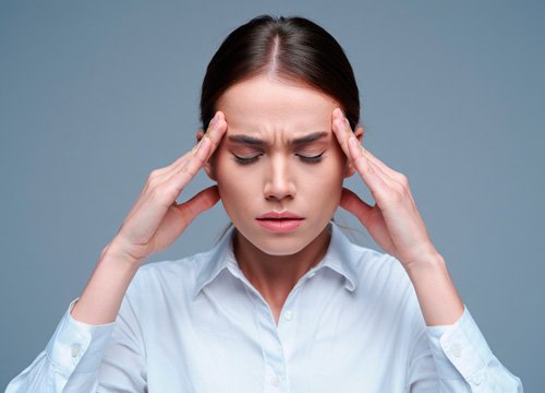 Головная боль у девушки Девушка держится за голову